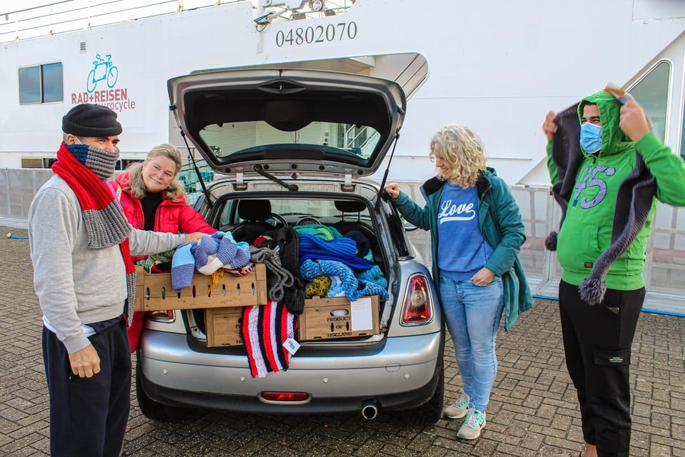 Simone van Mensch (l) en Lisette Otto met een auto vol sjaals voor de asielzoekers van de hotelboot in Huizen.
