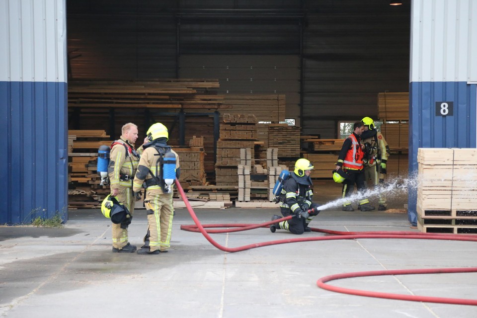 Oververhitte houtsnippers (buiten beeld) worden door de brandweer met bluswater afgekoeld.