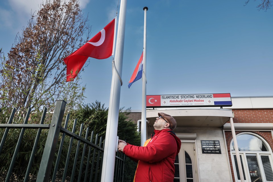 Met een bedroefd gezicht hangt Mustafa Karatas de Turkse vlag half stok