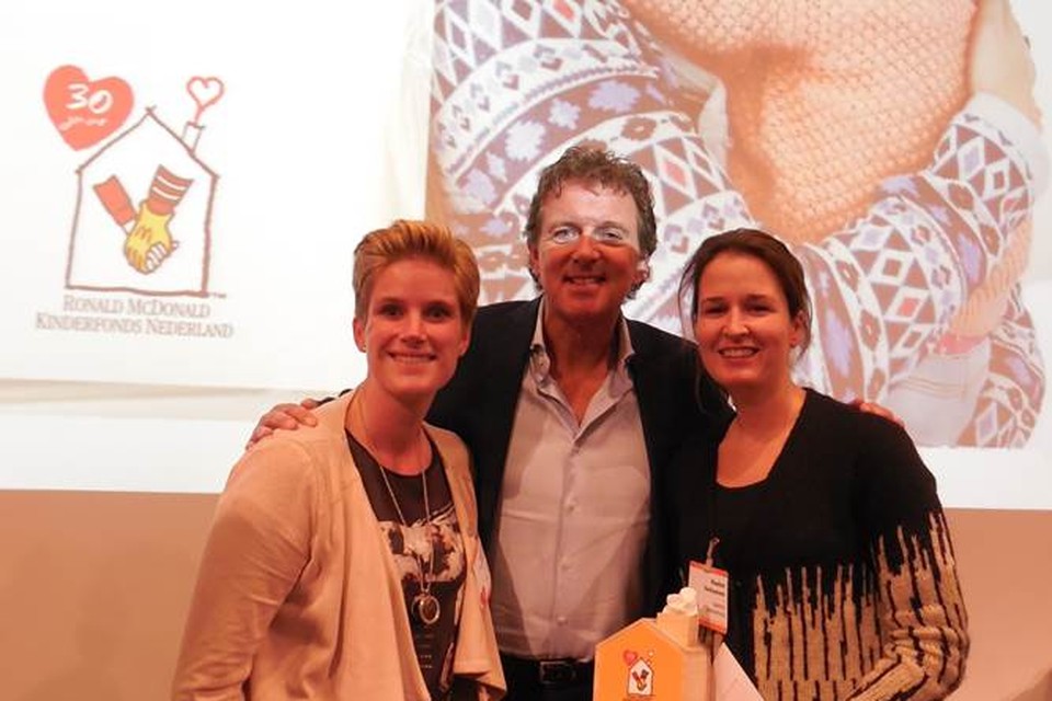 Robert ten Brink overhandigt symbolisch het jubileumbudget aan de pedagogisch medewerkster Annemarie en Rosina.