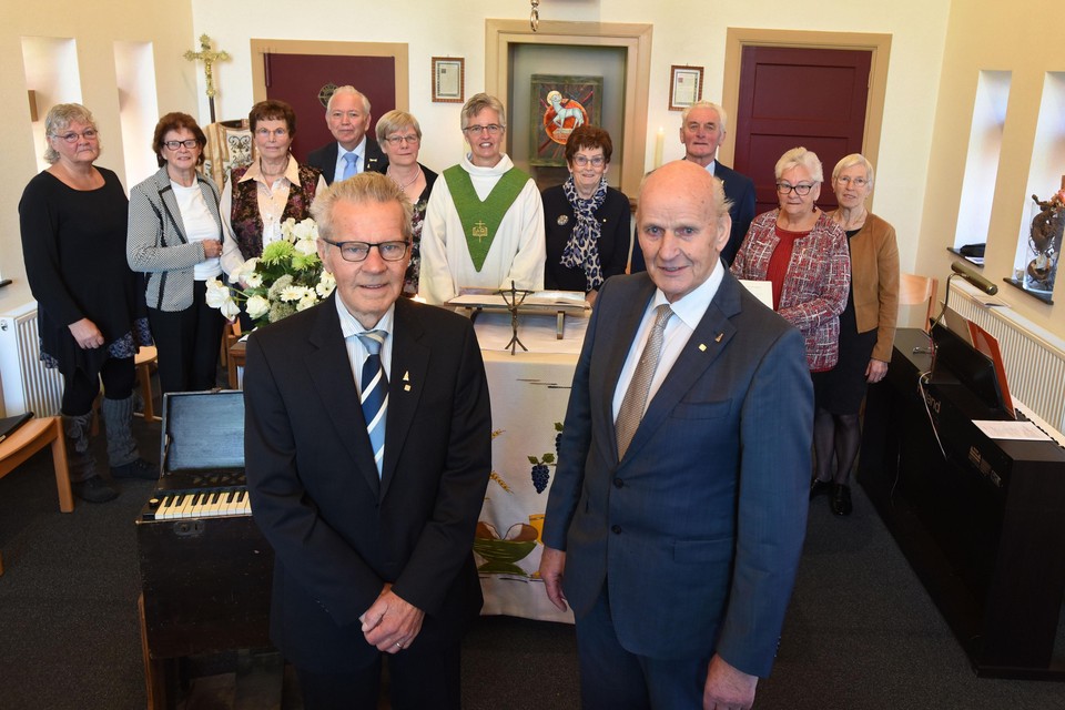 Jan Tromp (r) en Bertus Klaver worden gehuldigd vanwege 65 jaar koorzang in kerkelijk verband.