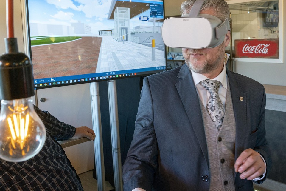 Wethouder Marcel van Zon bekijkt met een VR-bril hoe het station Alkmaar Noord er straks uitziet.