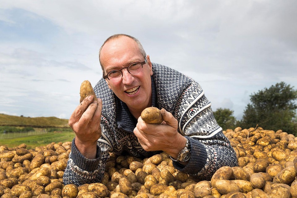 Marc van Rijsselberghe op een berg zilte aardappels.