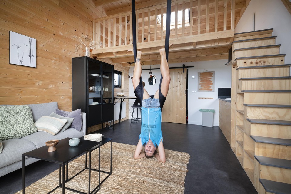 Suus demonstreert aerial yoga in haar tiny house.