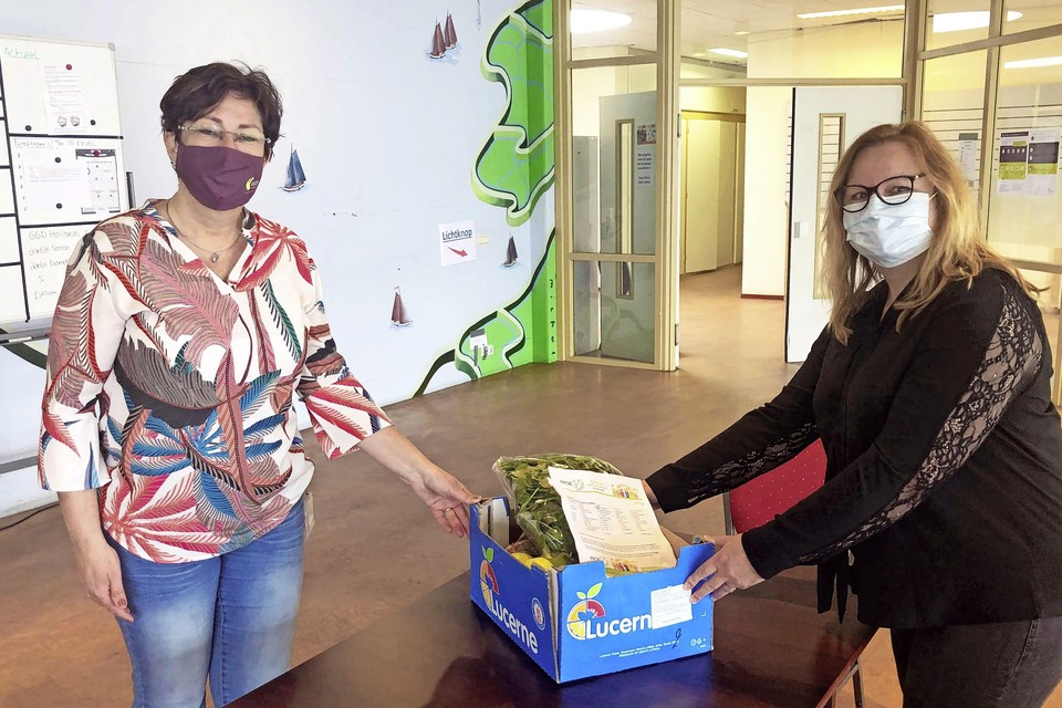 Liesbeth Henningheim van Incotec (rechts) overhandigt de fruit/groentepakketten aan Esther Duin, teamleider van de teststraten bij GGD Hollands Noorden (links).
