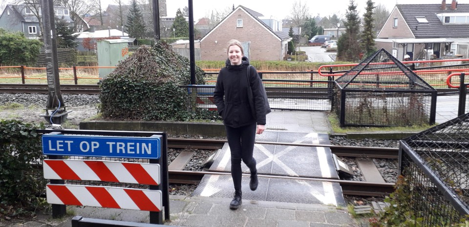 Amy Huijberts wandelt over de onbeveiligde spoorovergang in Obdam.