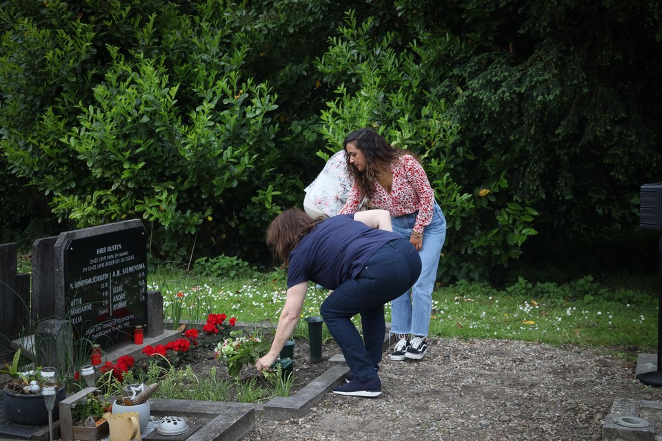 Aartje legt een boeketje duizenschoon op het graf, de lievelingsbloemen van haar moeder.