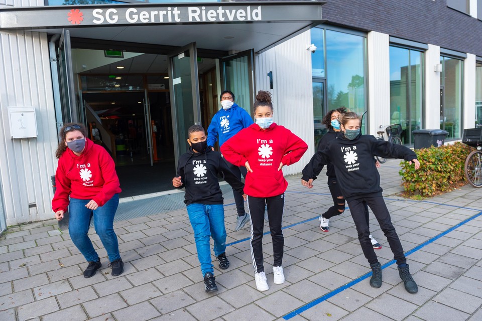 Leerlingen SG Gerrit Rietveld in Purmerend met mondkapjes tegen corona en hoodies tegen de kou in het lokaal (raam open voor ventilatie).
