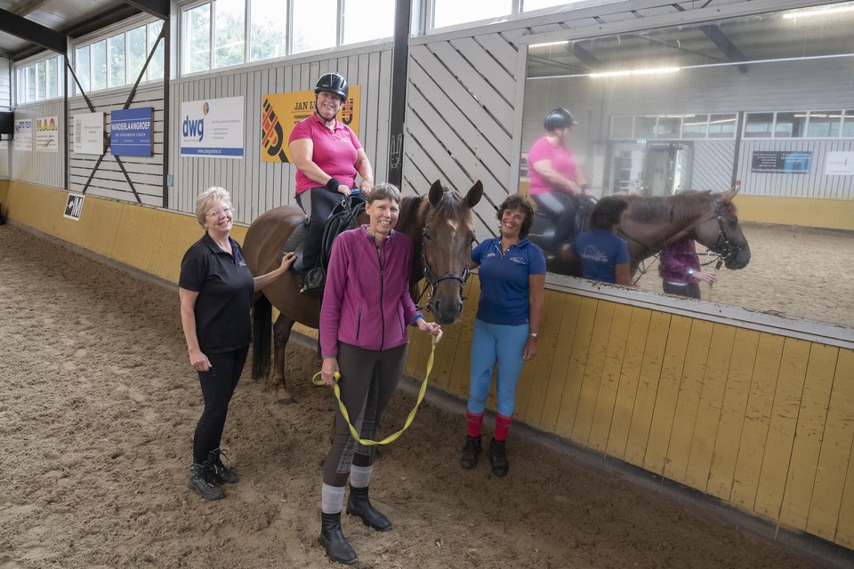 Bianca Vernouwt krijgt rijles op paard Sibbel, begeleid door instructrice Mick A-Tjak (links), Toos van der Heijden en instructrice Edith Blok (rechts ).